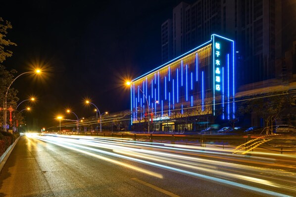 A modern building with vertical light strips and signage.
