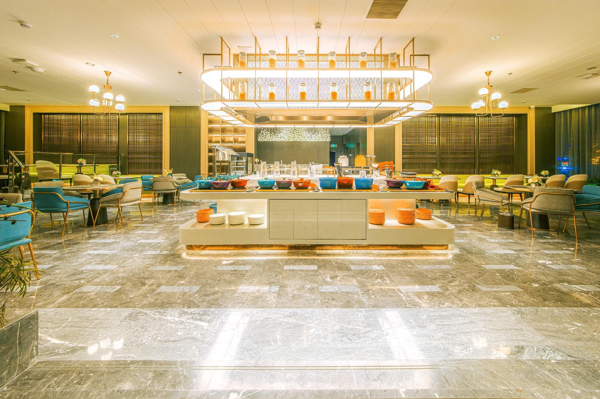 A hotel lobby with a central buffet area, seating arrangements, and a decorative ceiling.