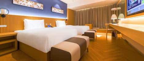 A hotel room with a large bed, bedside tables, a desk, and a television.