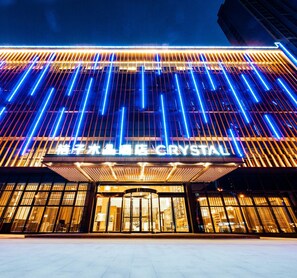 A building facade with illuminated vertical lines and a sign that reads 'THE CRYSTAL.' - Crystal Orange Hotel Xinyi Center (Xuzhou)