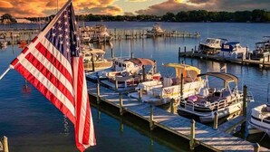 A marina with docked boats and an American flag. - Colonial Beach Cottage, 7 minutes walk to beach! (Colonial Beach)