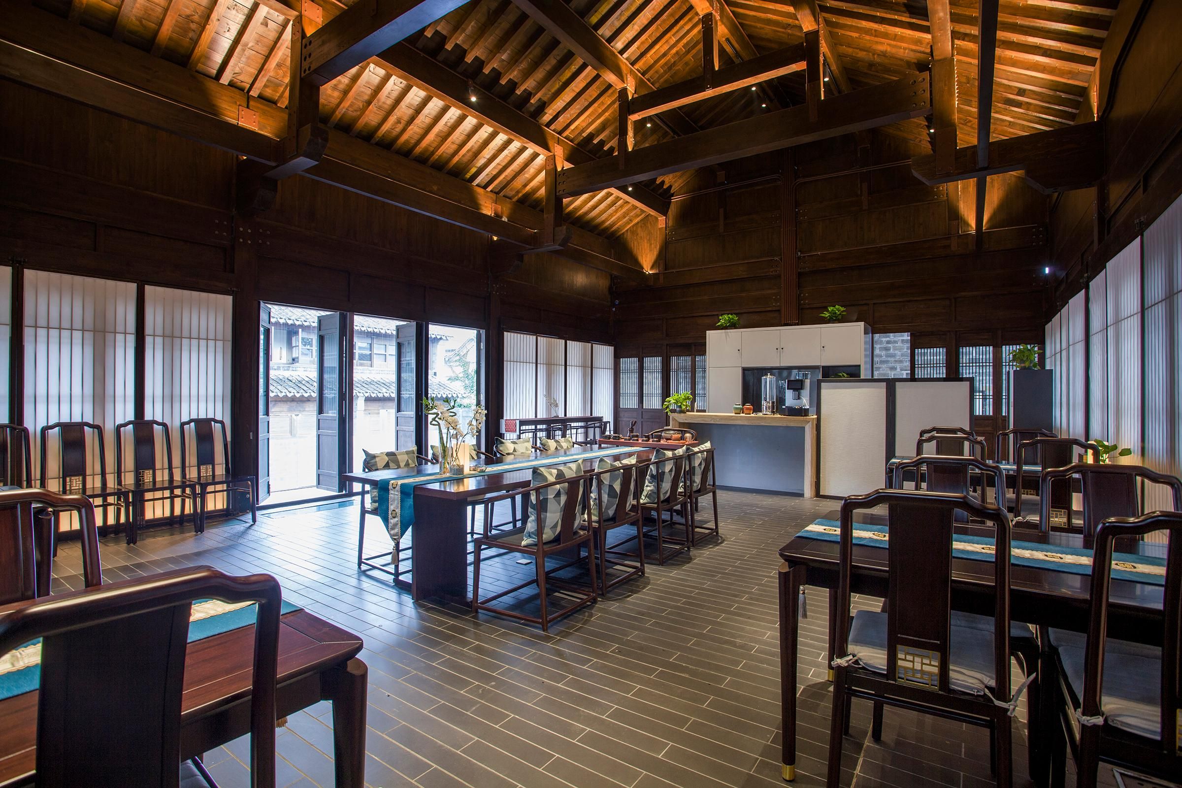 A spacious dining area with wooden furniture and large windows.