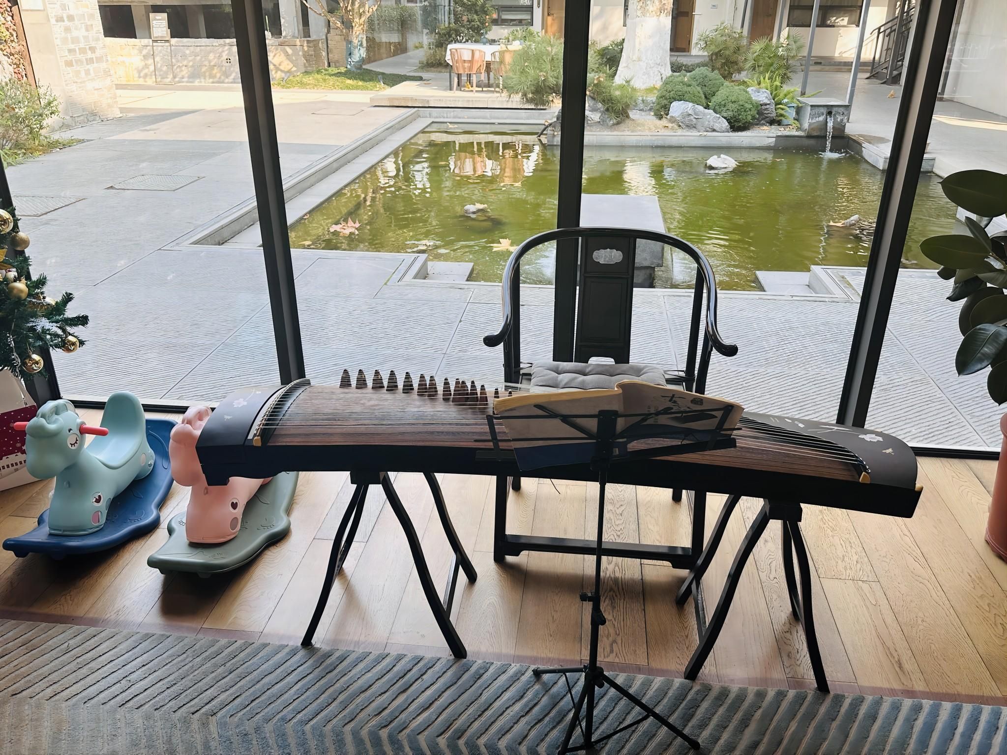 Ein Zimmer mit Blick auf einen Innenhof, ein Klavier und zwei Spielzeugautos für Kinder.