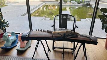 Ein Zimmer mit Blick auf einen Innenhof, ein Klavier und zwei Spielzeugautos für Kinder.