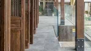 A covered walkway with wooden pillars and a tiled floor. - Blossom Hill Hotel Nanjing Laomendong Zhuqueli (Nanjing)