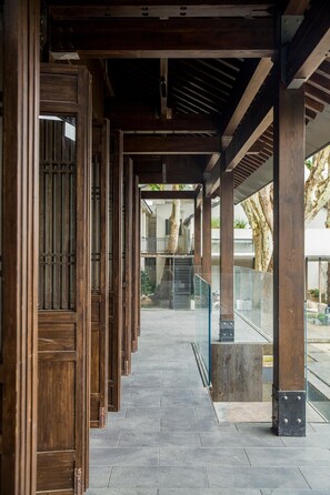 A covered walkway with wooden columns and a tiled floor. - Blossom Hill Hotel Nanjing Laomendong Zhuqueli (Nanjing)