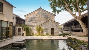 A stone building with a water feature in front. - Blossom Hill Hotel Nanjing Laomendong Zhuqueli (Nanjing)