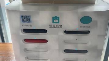 Un quiosco de autoservicio con un código QR para escanear, una interfaz de pago y una pantalla digital.
