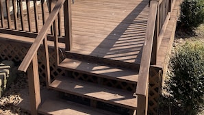 A wooden deck with a railing, a covered patio area, and a staircase leading to a house. - Newly remodeled offers many amenities with perfect location! (Ironton)