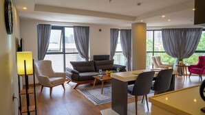 Una sala de estar moderna con un sofá, sillones, una mesa de comedor y una mesa de centro.