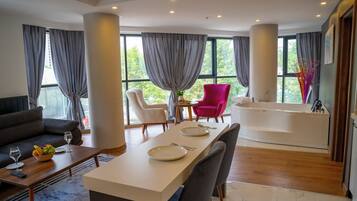 Relax in a spacious room with a large window, sitting area, and separate bathtub.