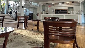 A spacious lobby with a chandelier, wooden chairs, a patterned rug, and a staircase leading to an upper level. - OCEAN Front Kona Studio - Spectacular view! (Kailua-Kona)