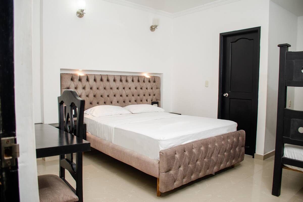 Une chambre à coucher avec un lit, un bureau et une chaise.