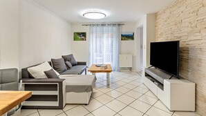 Una sala de estar moderna con sofá, mesa de centro, televisor y chimenea.