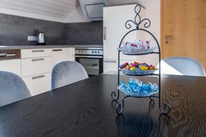 A dark wooden table with a metal stand holding snacks and a glass bowl.