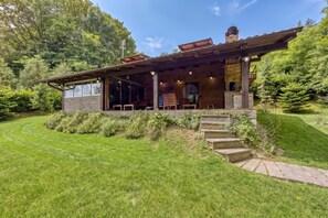 Une maison moderne en bois, dotée d’un porche couvert, d’une façade en briques et d’une pelouse bien entretenue.