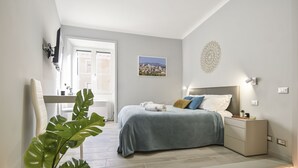 Een slaapkamer met een bed, nachtkastje en een raam.