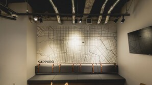 Un interno moderno con una grande mappa a parete, una panca e tavoli in legno.
