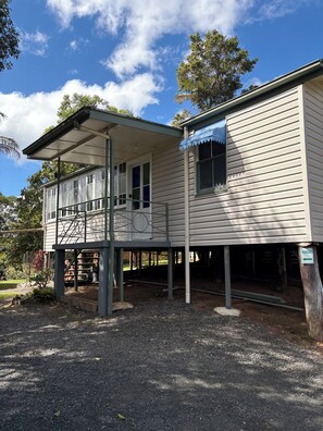 A two-story building with a covered porch and a visible staircase. - Tablelands Tranquil Retreat (Jaggan)