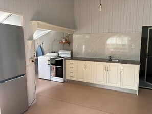 Una cocina equipada con refrigerador, estufa, pileta y alacenas.