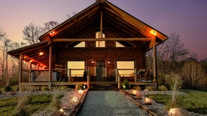 A log cabin with a large front porch, multiple windows, and a gravel pathway leading to the entrance. - Stunning Hocking Hills Views, Huge Skies ~ Sauna, Pet Friendly, Hot Tub, WiFi (new plymouth)