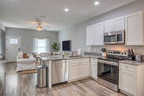 A modern kitchen with white cabinets, stainless steel appliances, and a granite countertop. - Fire pit, Pet Friendly, Only 1 Mile to Beach, 4 Miles to Historic Downtown, $300 in Free Tickets! (St. Augustine)