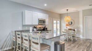 A kitchen with white cabinets, a granite countertop, and a stainless steel trash can. - Fire pit, Pet Friendly, Only 1 Mile to Beach, 4 Miles to Historic Downtown, $300 in Free Tickets! (St. Augustine)