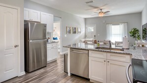 A modern kitchen with stainless steel appliances, white cabinetry, and a granite countertop. - Fire pit, Pet Friendly, Only 1 Mile to Beach, 4 Miles to Historic Downtown, $300 in Free Tickets! (St. Augustine)
