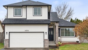 A two-story house with a garage, a black front door, and a mailbox. - Wonderfully Updated, Pet Friendly, Open Layout, Pool Table, BBQ, Next to Edgefield Golf and Concerts (Troutdale)