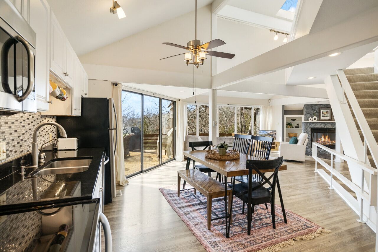 Una cocina amplia con comedor, ventanas grandes y chimenea.