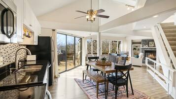 Una cocina amplia con comedor, ventanas grandes y chimenea.