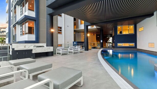 Una piscina interior con sillones de descanso y un diseño arquitectónico moderno.