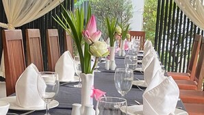 A table set for a formal dining experience with white tablecloths, neatly folded napkins, and clear glassware. - Crystal Hotel (Siem Reap)