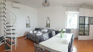 Una habitación con una cama, una mesa de comedor y una escalera.