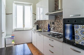 Effortlessly prepare meals in this well-equipped kitchen with a gas stove, oven, and ample counter space.