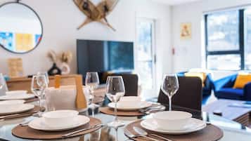Comedor con mesas redondas, platos blancos y copas de vino preparadas para una comida.