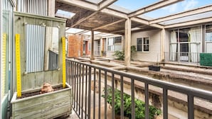 A residential building with a balcony, a terracotta frog planter, and a brick wall. - Walker's Paradise + Espresso Machine + King Bed (Atlanta)