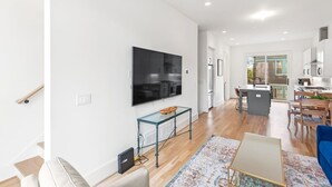 A modern living room with a flat-screen TV, a glass coffee table, and a patterned rug. - Second Floor Balcony | EV Charger |King Bed (Atlanta)