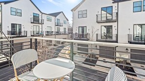 A modern apartment complex with multiple units, balconies, and a rooftop terrace with outdoor seating. - Fast Wifi|Downtown EAV| EAV Retreat (Atlanta)