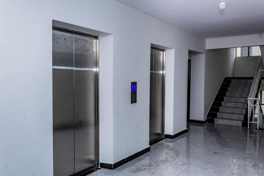A hallway with two elevators and a staircase.