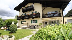 A two-story building with balconies, outdoor seating, and a well-maintained garden. - Tranquil apartment in the centre of Seefeld (Seefeld in Tirol)