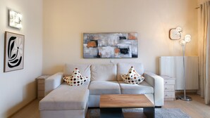 A modern living room with a sofa, a coffee table, a side table, and a floor lamp. - Tranquil apartment in the centre of Seefeld (Seefeld in Tirol)