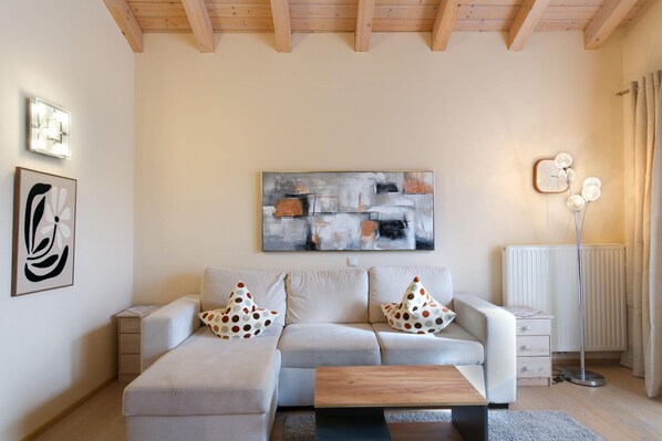 A modern living room with a sofa, a coffee table, a side table, and a floor lamp.