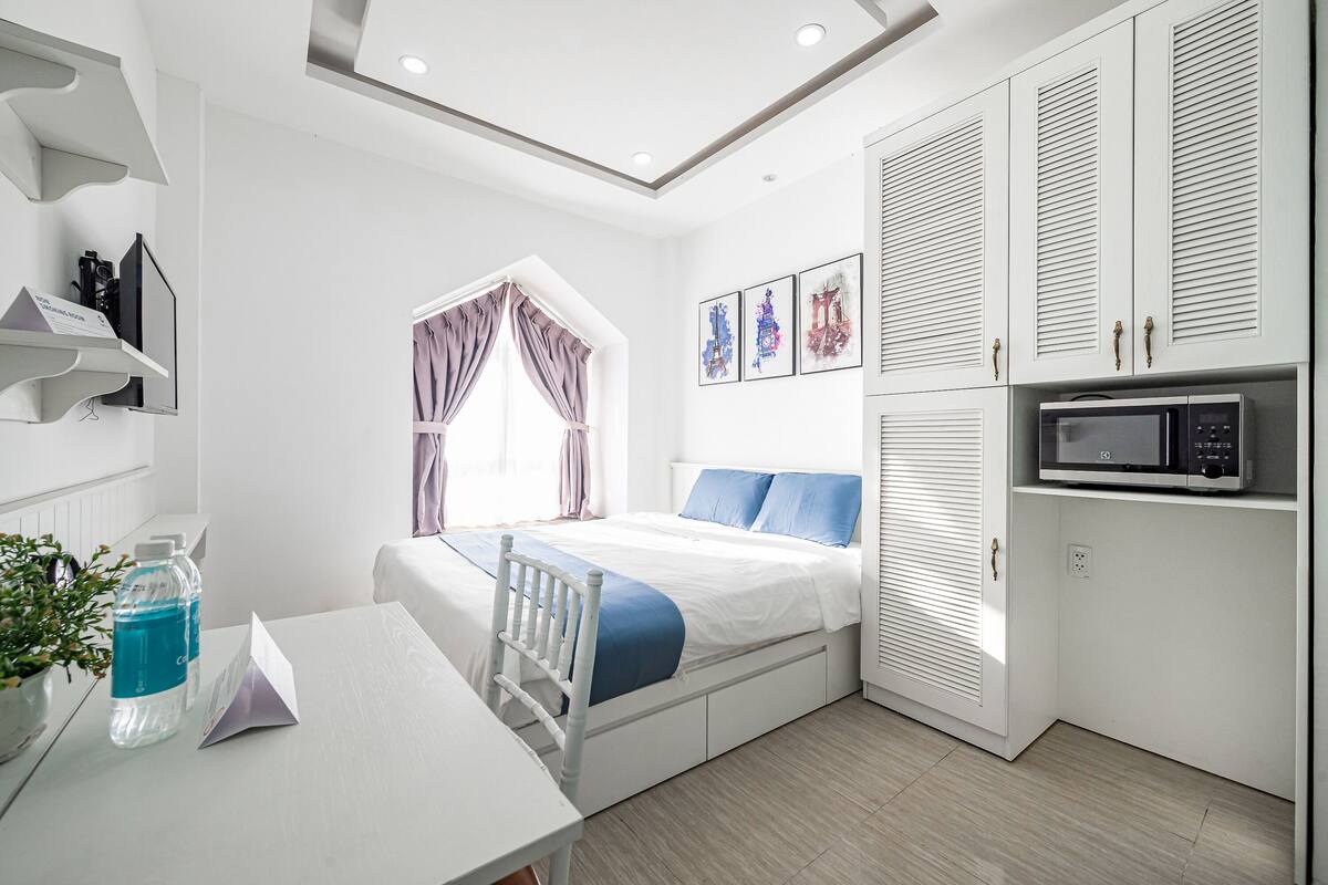 A modern bedroom with a bed, bedside table, and a built-in wardrobe.