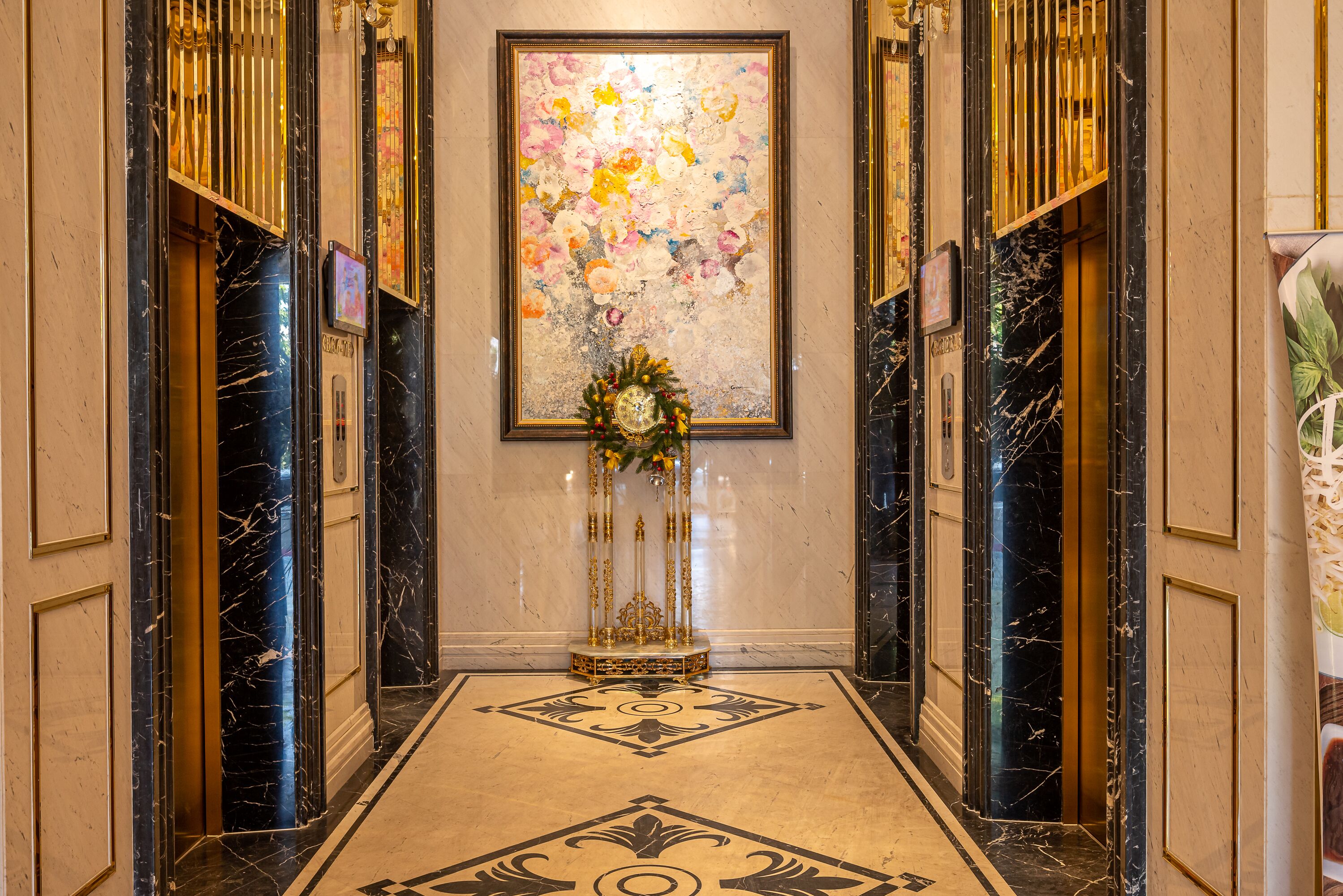 A hallway with marble walls, a decorative floral arrangement, and a large abstract painting on the wall.