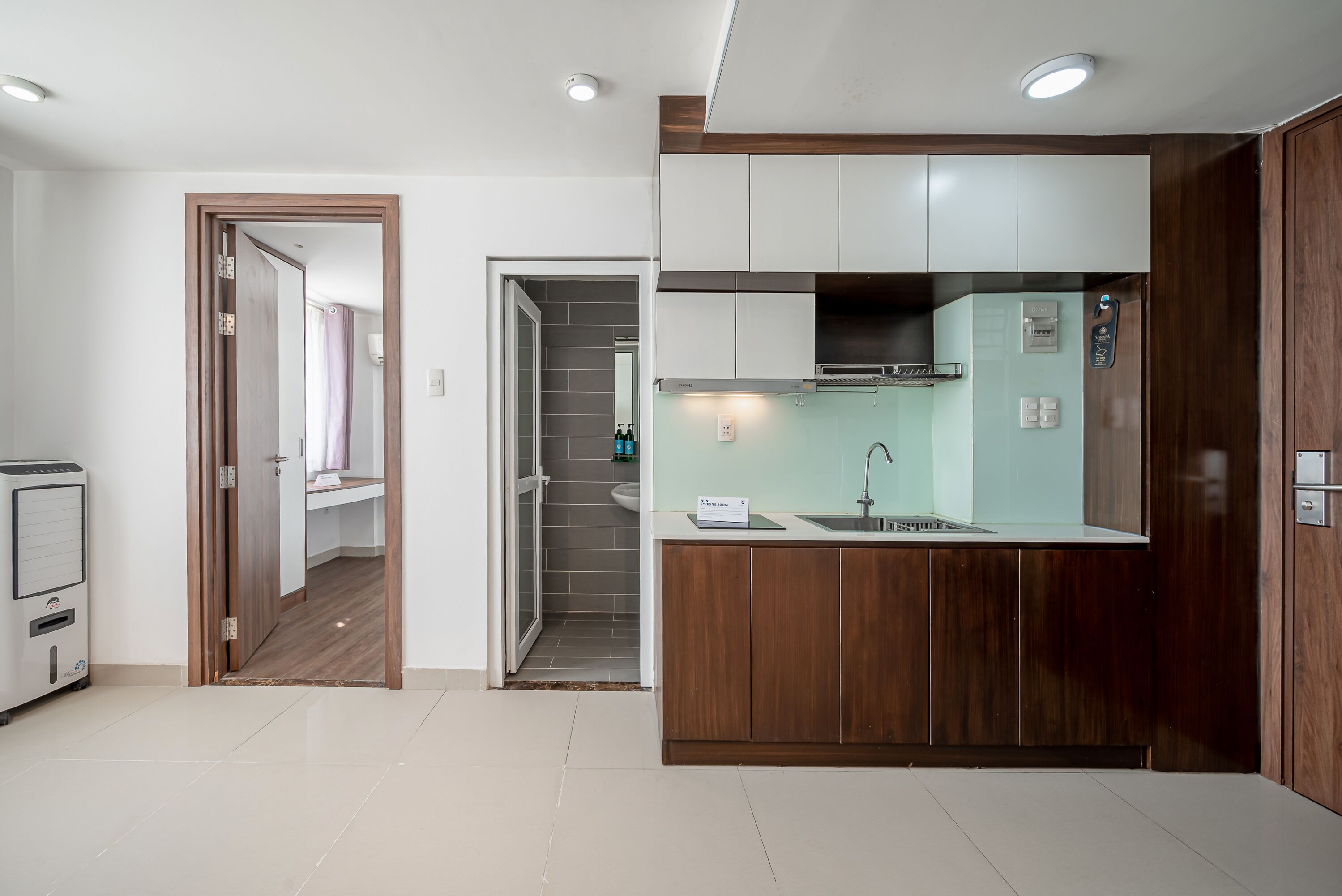 A modern kitchen with white cabinets, a stainless steel sink, and a built-in oven.