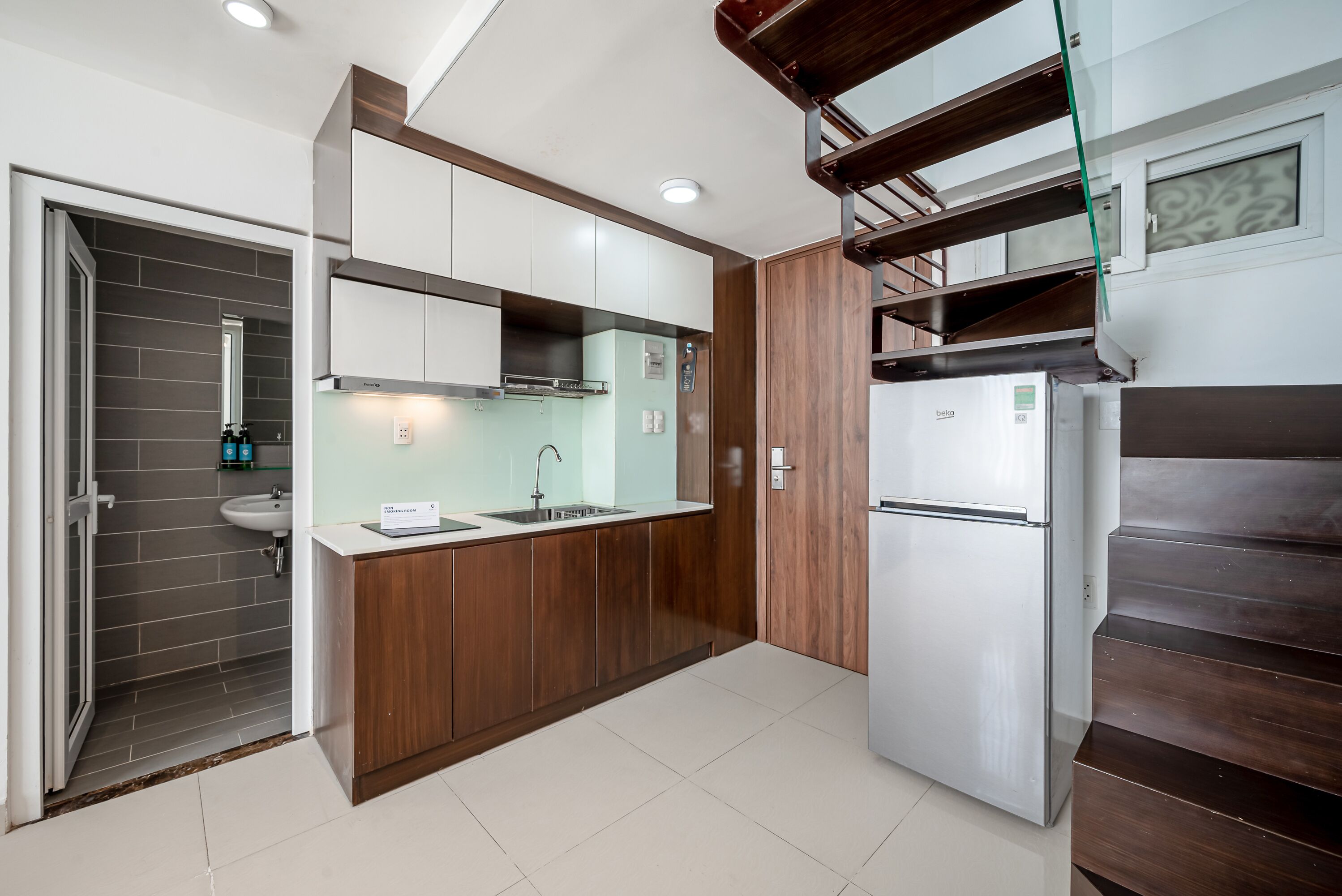 Una cocina moderna con lavavajillas integrado, un fregadero y un refrigerador.