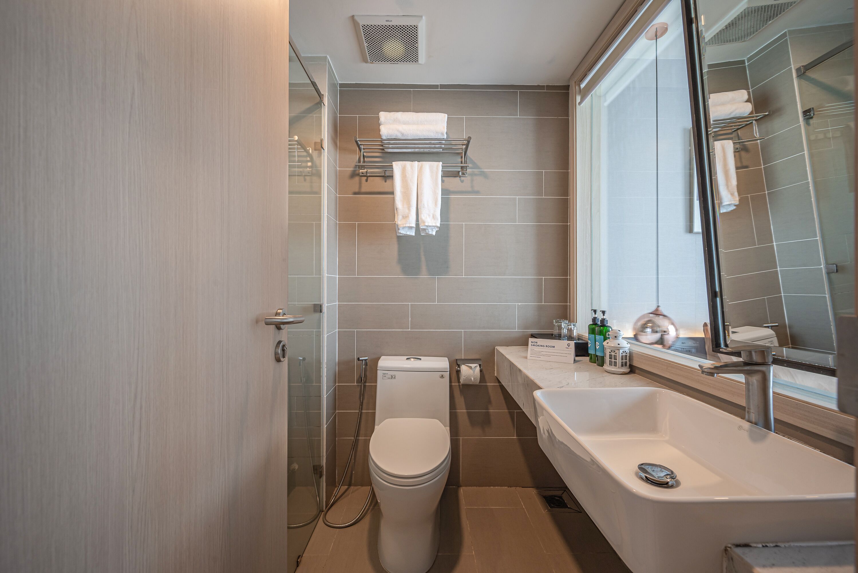A modern bathroom with a toilet, shower, and sink.
