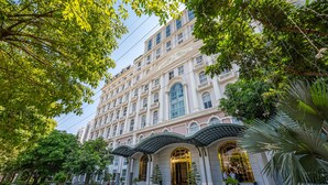 Ein mehrstöckiges Hotel mit einer klassischen Fassade, großen Fenstern und einem zentralen Eingang mit Vordach.
