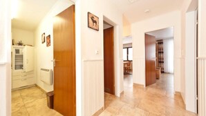 A hallway with wooden doors, a white radiator, and a picture of a moose on the wall. - Allgäu Family Retreat (Nesselwang-Reichenbach)